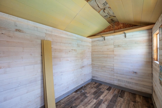 unfurnished room featuring wood walls, dark wood-type flooring, and lofted ceiling