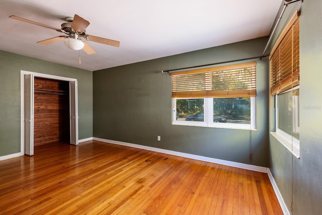 unfurnished bedroom featuring ceiling fan, a closet, and wood-type flooring