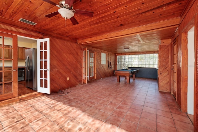 rec room featuring french doors, wooden ceiling, wood walls, light tile patterned floors, and pool table