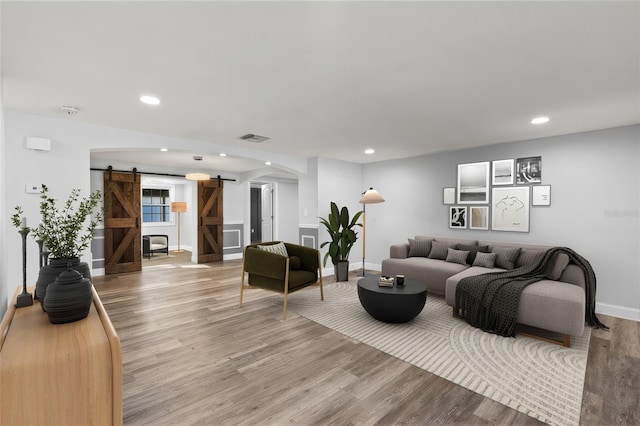 living room with wood-type flooring and a barn door