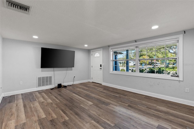 unfurnished living room featuring a textured ceiling and hardwood / wood-style flooring