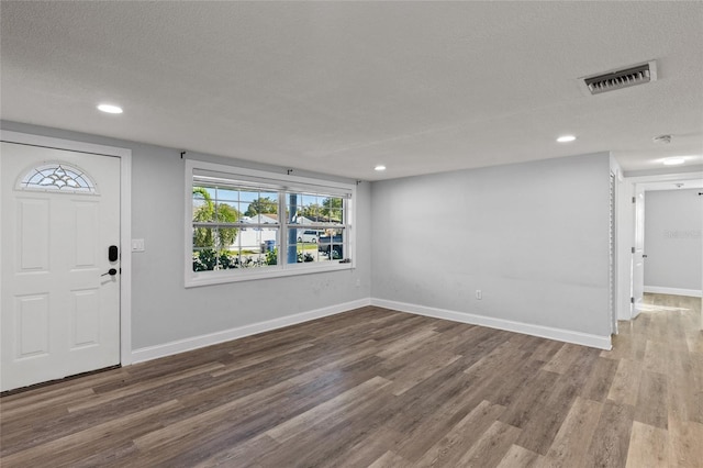 foyer featuring wood-type flooring and a textured ceiling