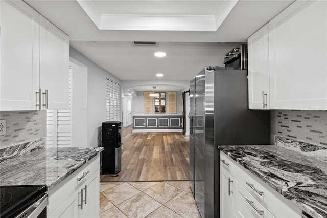 kitchen featuring stone counters, light hardwood / wood-style floors, white cabinetry, and tasteful backsplash