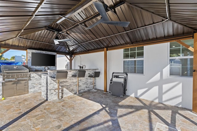 view of patio / terrace featuring a gazebo, a grill, ceiling fan, and exterior kitchen