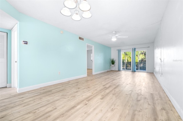 unfurnished living room with ceiling fan with notable chandelier and light wood-type flooring