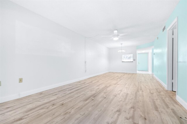 empty room with ceiling fan and light hardwood / wood-style flooring