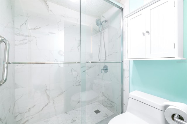 bathroom with toilet, a shower with door, and a textured ceiling