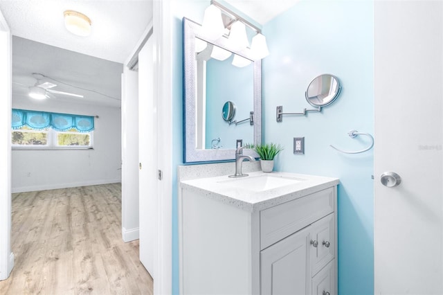 bathroom featuring ceiling fan, hardwood / wood-style floors, and vanity