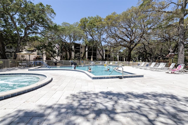 view of pool with a patio area and a hot tub