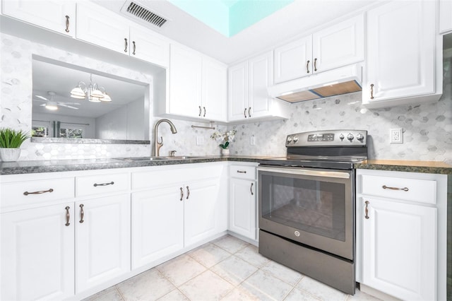 820 Patricia Ave Unit 207, Dunedin, FL 34698 - kitchen featuring stainless steel electric range, under cabinet range hood, a sink, white cabinetry, and dark countertops