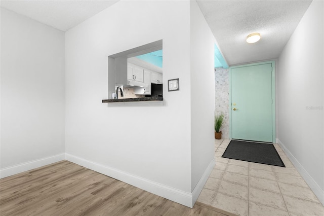 820 Patricia Ave Unit 207, Dunedin, FL 34698 - hallway with baseboards, a textured ceiling, and wood finished floors