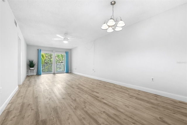 820 Patricia Ave Unit 207, Dunedin, FL 34698 - empty room featuring wood finished floors, a chandelier, baseboards, a ceiling fan, and a textured ceiling