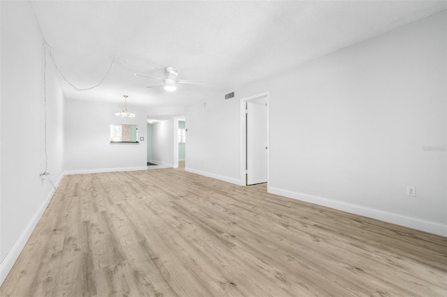 820 Patricia Ave Unit 207, Dunedin, FL 34698 - unfurnished living room with a ceiling fan, light wood finished floors, a chandelier, and baseboards