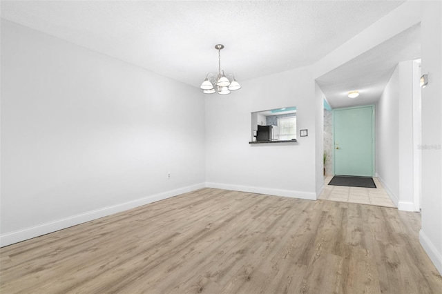 820 Patricia Ave Unit 207, Dunedin, FL 34698 - unfurnished dining area with a chandelier, wood finished floors, and baseboards