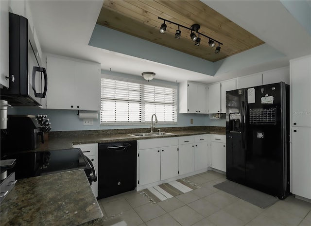 kitchen featuring sink, light tile patterned floors, a tray ceiling, white cabinets, and black appliances