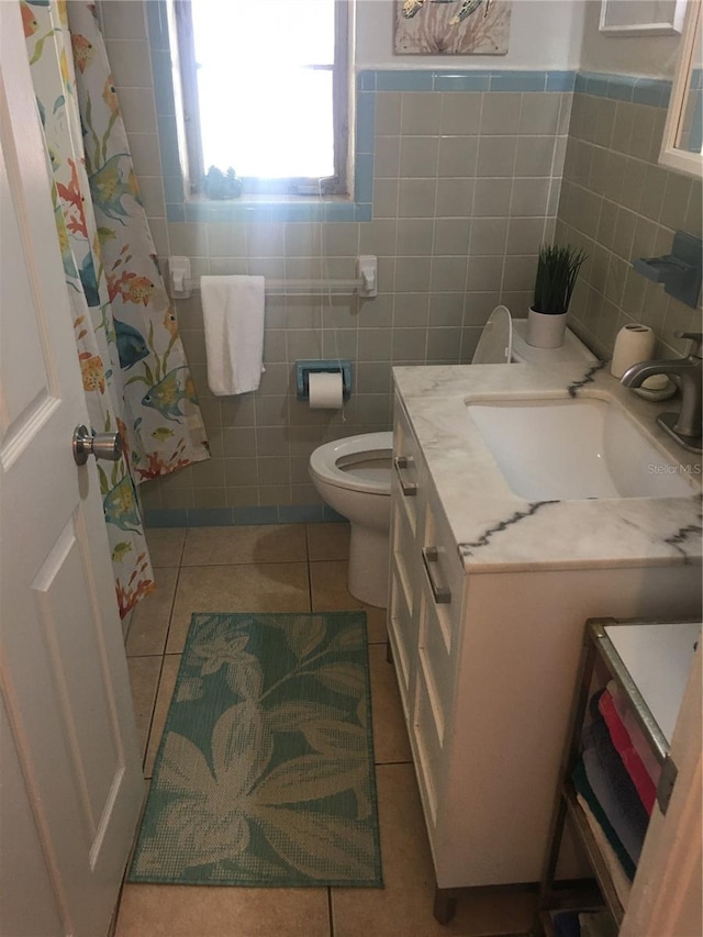 78 146th Ave E, Madeira Beach, FL 33708 - full bathroom featuring vanity, tile patterned floors, toilet, tile walls, and curtained shower