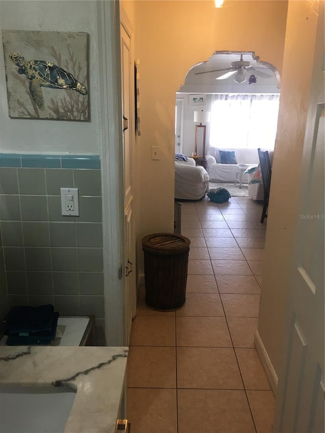 78 146th Ave E, Madeira Beach, FL 33708 - hall featuring light tile patterned floors, arched walkways, and a sink