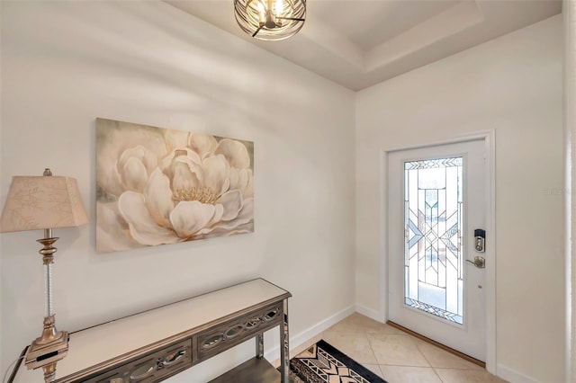 tiled entrance foyer with a tray ceiling