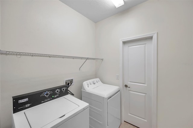 clothes washing area featuring washer and dryer and a textured ceiling