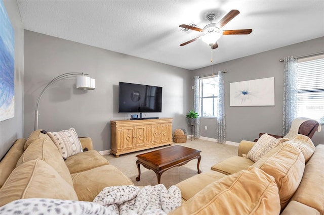 living room featuring ceiling fan and a textured ceiling