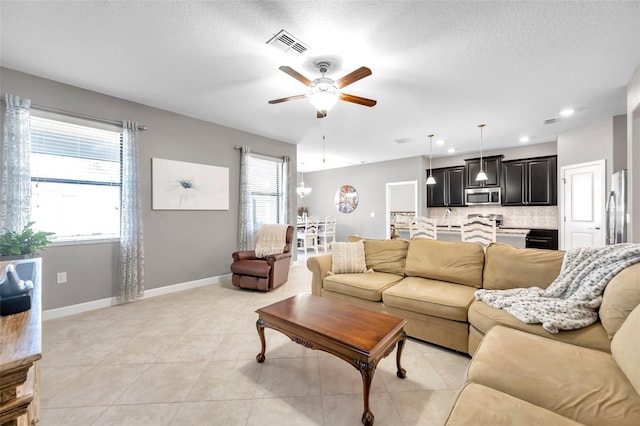 tiled living room featuring ceiling fan and a textured ceiling