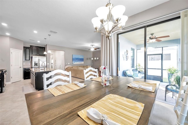 dining area featuring ceiling fan with notable chandelier, light tile patterned floors, and sink