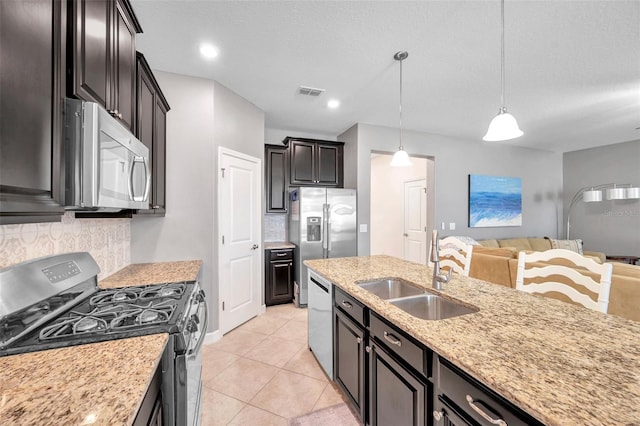 kitchen with sink, tasteful backsplash, pendant lighting, light tile patterned floors, and appliances with stainless steel finishes