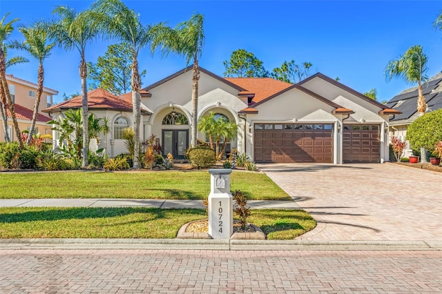 mediterranean / spanish home with a front yard, french doors, and a garage