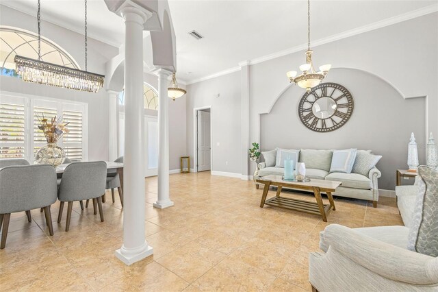 tiled living room with decorative columns, a towering ceiling, a chandelier, and ornamental molding