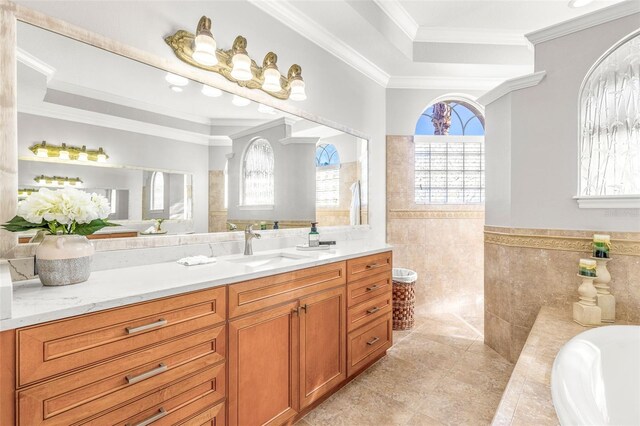 bathroom with vanity, a bathtub, tile patterned floors, ornamental molding, and tile walls