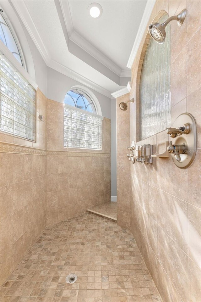 bathroom with a tile shower and crown molding