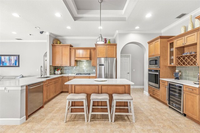 kitchen featuring a center island, sink, stainless steel appliances, a kitchen breakfast bar, and wine cooler