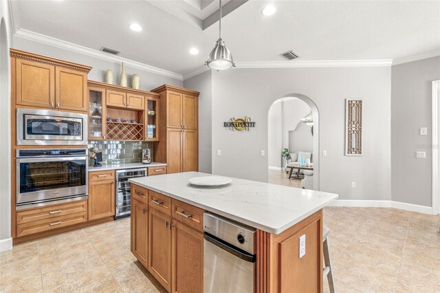 kitchen featuring beverage cooler, stainless steel appliances, crown molding, decorative backsplash, and a kitchen island