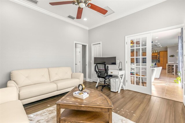 living room with ceiling fan, wood-type flooring, ornamental molding, and french doors