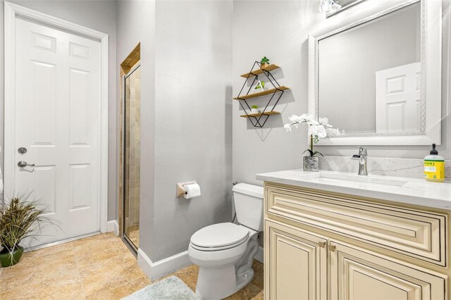 bathroom with vanity, toilet, and a shower with door