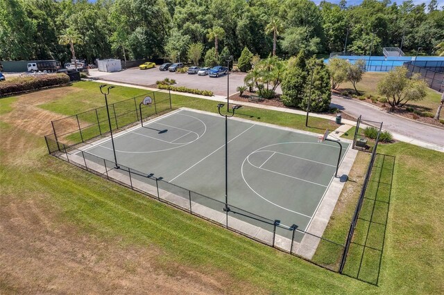 view of sport court featuring a lawn