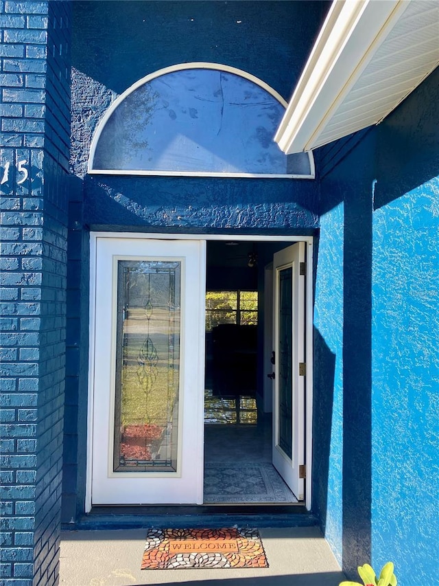 view of exterior entry featuring brick siding