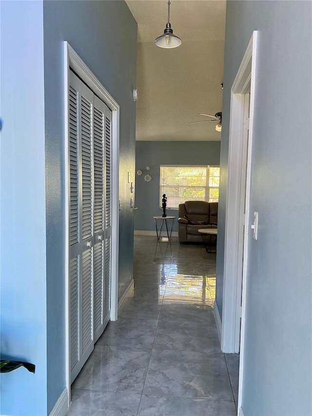 corridor with concrete floors and baseboards