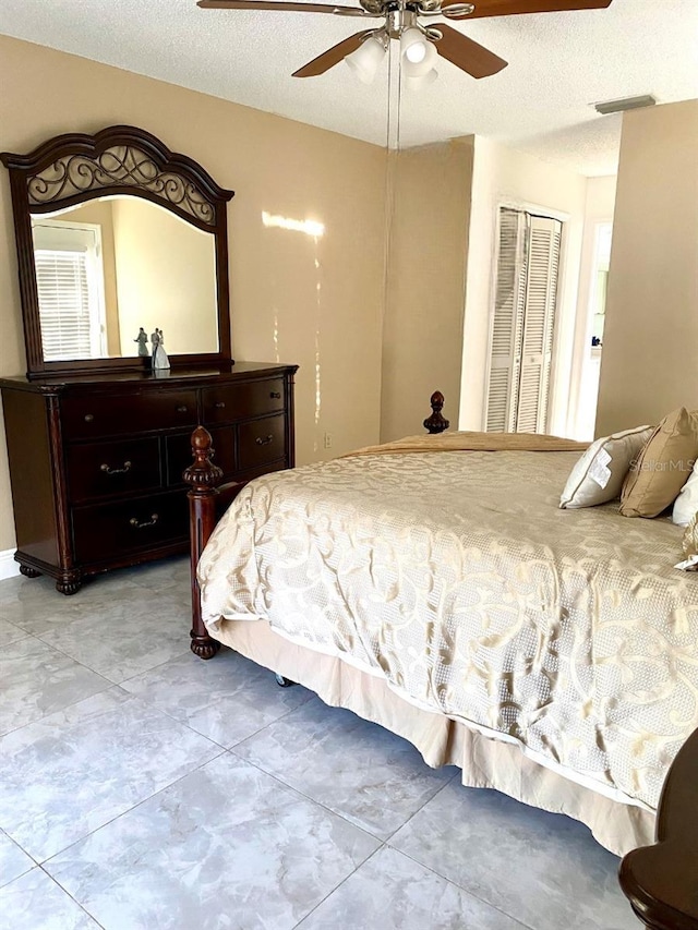 bedroom featuring ceiling fan, a closet, and a textured ceiling