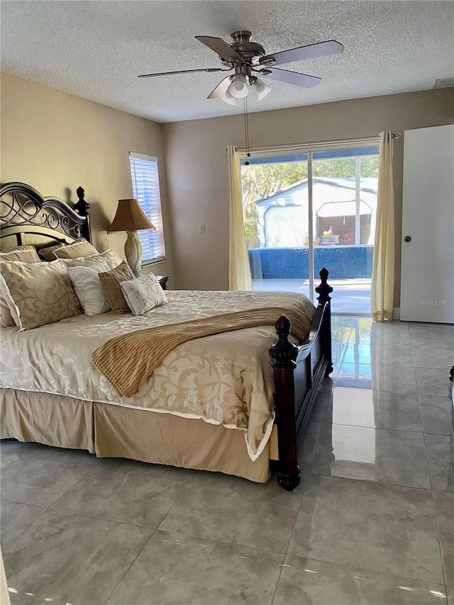 bedroom with access to exterior, a textured ceiling, and ceiling fan