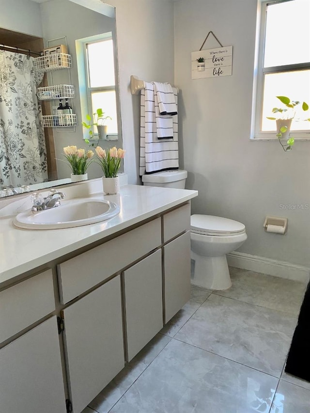 bathroom with baseboards, toilet, tile patterned floors, curtained shower, and vanity