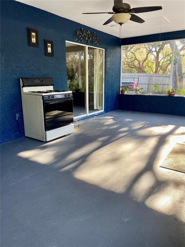 view of patio with ceiling fan and fence