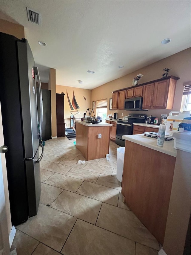 13404 Hampton Park Ct, Fort Myers, FL 33913 - kitchen featuring appliances with stainless steel finishes, a center island, light countertops, brown cabinets, and light tile patterned flooring