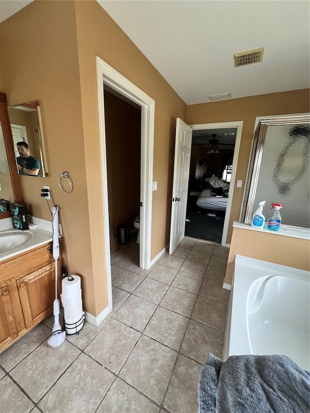 full bathroom featuring tile patterned floors, vanity, shower with separate bathtub, and toilet