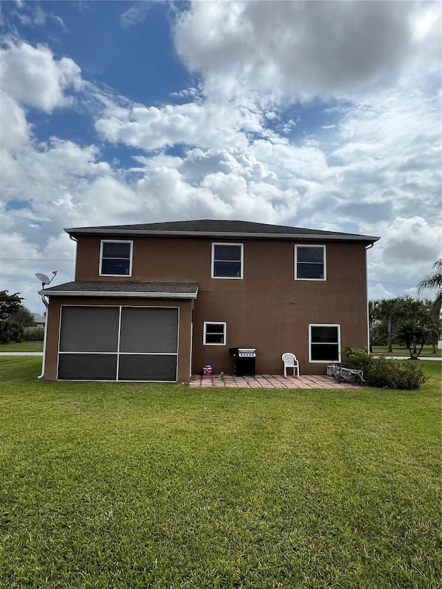rear view of house featuring a yard and a patio