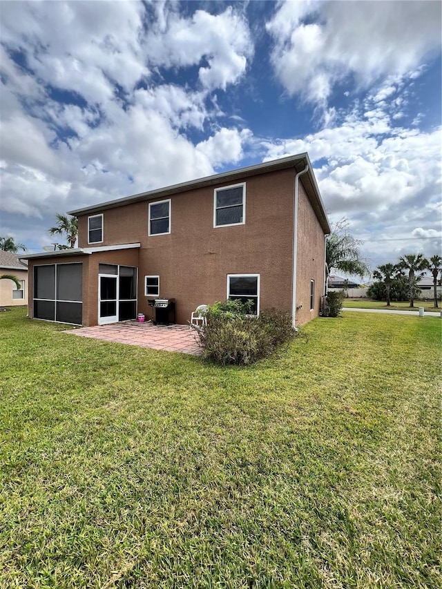 13404 Hampton Park Ct, Fort Myers, FL 33913 - rear view of house featuring stucco siding, a lawn, a sunroom, and a patio area