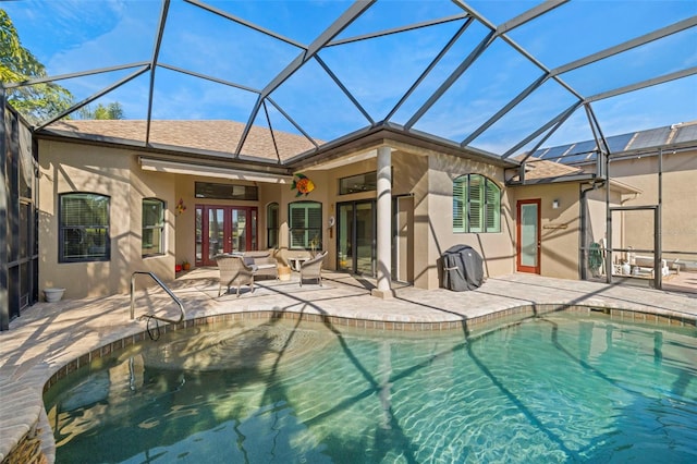 view of swimming pool featuring a lanai, ceiling fan, french doors, and a patio