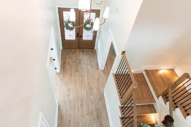 interior space featuring french doors, a notable chandelier, and wood-type flooring