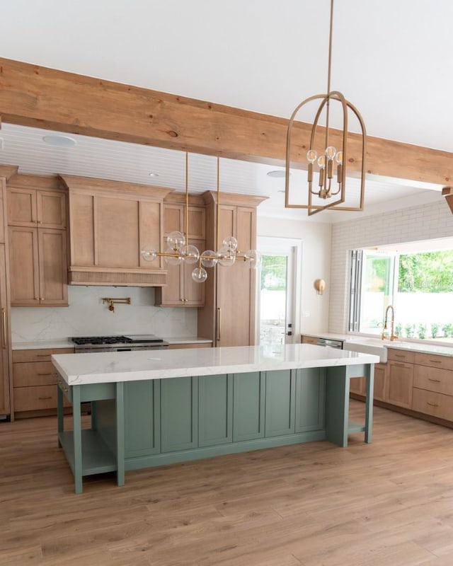 kitchen with an inviting chandelier, tasteful backsplash, pendant lighting, a spacious island, and light wood-type flooring