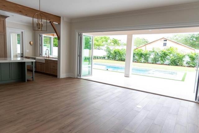 doorway featuring hardwood / wood-style floors, a healthy amount of sunlight, sink, and an inviting chandelier